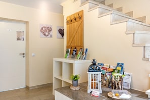 A reception area with a wooden door, a white reception desk, and a staircase.