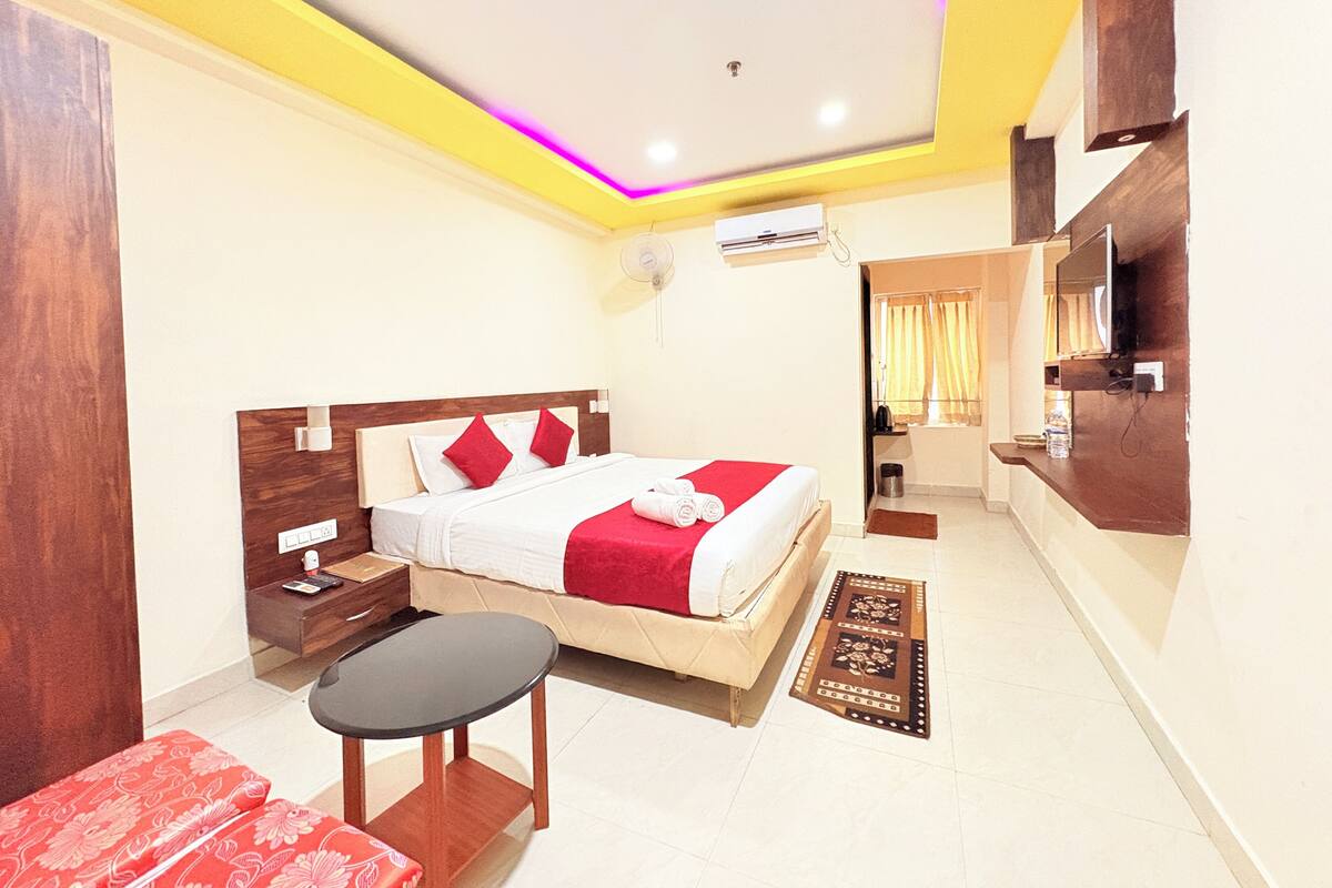 A hotel room with a bed, bedside table, and a small table.
