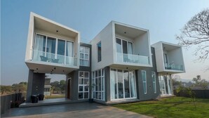 A modern multi-story house with large windows and balconies. - Suruchi Villa By Soumils Stays (Alibag)