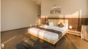 A modern bedroom with a large bed, a nightstand, a lamp, and a wardrobe. - Suruchi Villa By Soumils Stays (Alibag)
