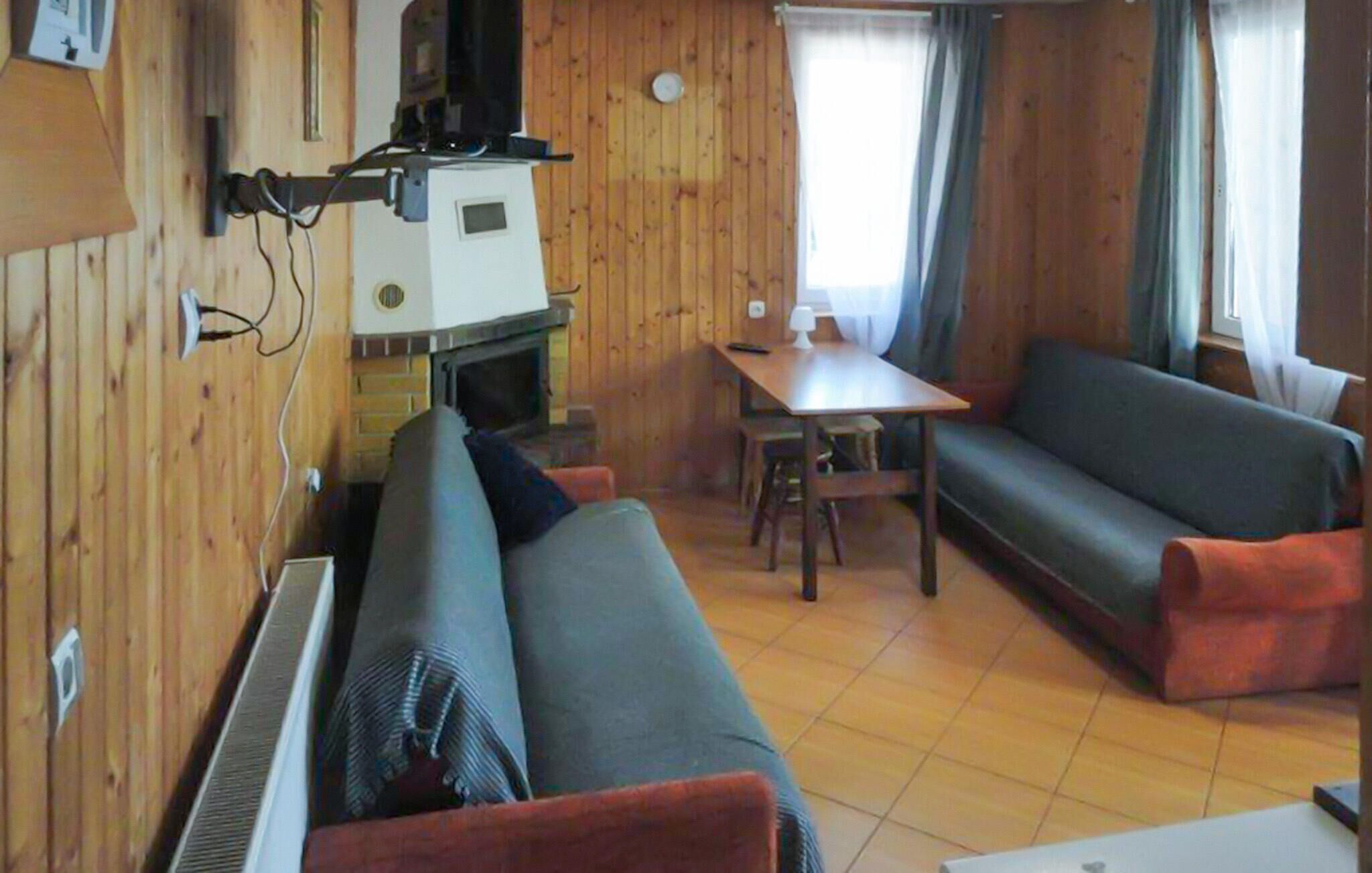 Een gezellige kamer met een bank, een eettafel en een kleine kitchenette.