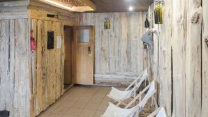 A wooden interior with a tiled floor, a wooden bench, and a door. - Beach front home in Ocypel with sauna (Ocypel)