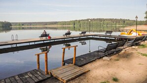 A lakeside dock with benches and a grill.