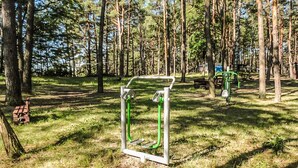A forested area with exercise equipment, a bench, and a playground structure. - Stunning home in Ocypel with sauna (Ocypel)