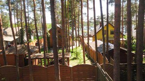 A forested area with wooden cabins and a yellow house.