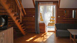 A wooden interior with a staircase, a sofa, and a table.