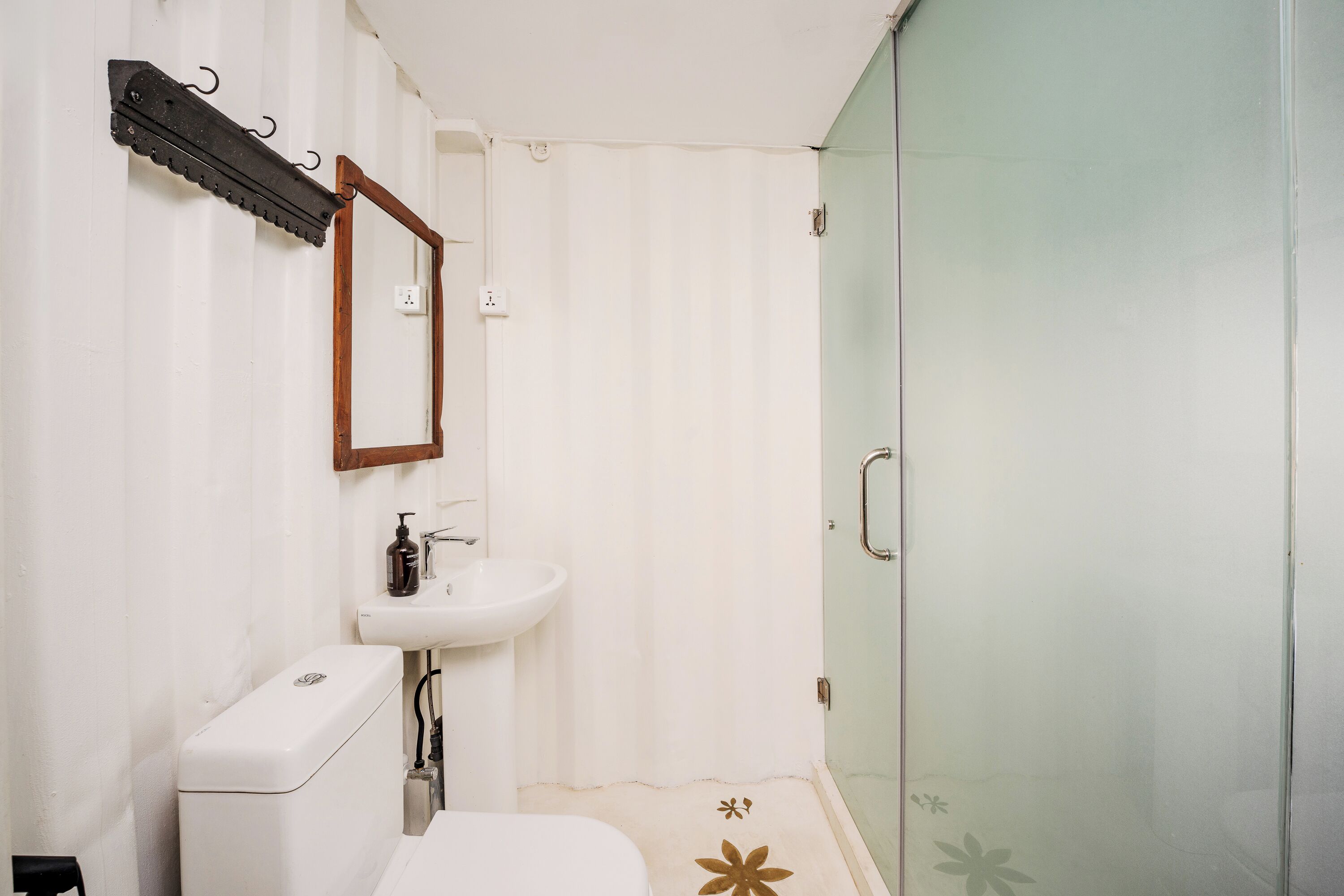 Un baño pequeño con inodoro, lavabo y cabina de ducha de vidrio.
