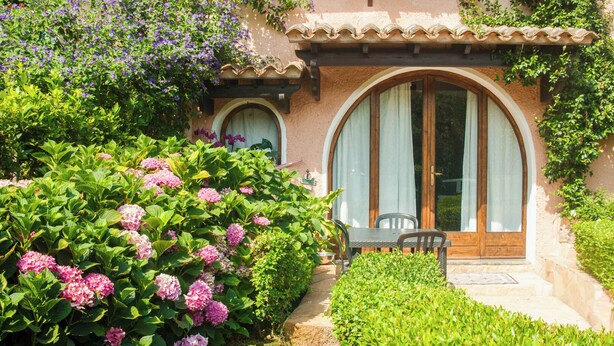 A house with a patio, a wooden table, and chairs. - VILLA GISA (Domus de Maria)