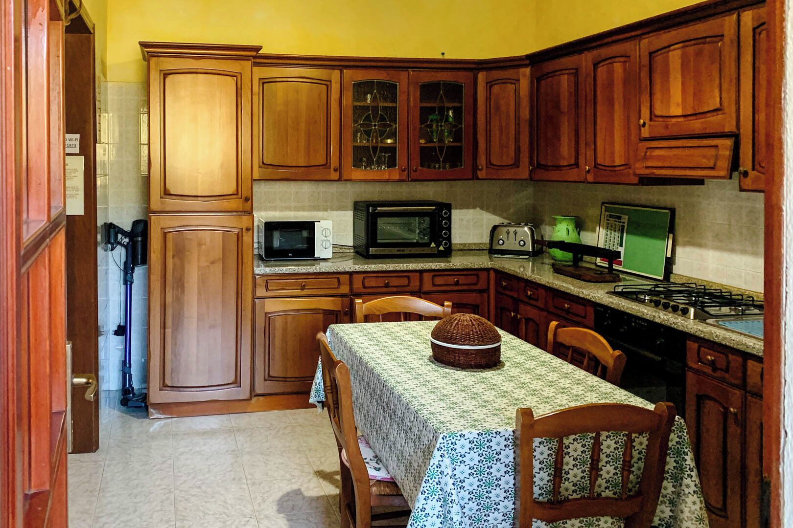 Una cocina compacta con armarios de madera, microondas, tostadora y estufa.