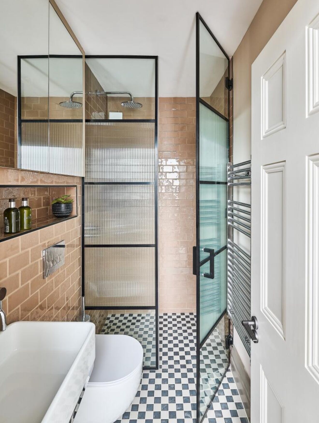 A bathroom with a shower, toilet, and a sink with a mirror.