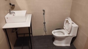 A small bathroom with a white sink, a toilet, and a shower head. - Townhouse Naksalbari Railway Station (Siliguri)