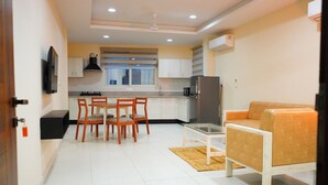 A compact living space with a dining area, kitchenette, and seating area. - AM SUITES LUXURY SERVICE APARTMENTS (Hyderabad)
