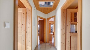 A hallway with wooden doors and a tiled floor, leading to a room with a view. - Holiday Apartment Ebnicher's Paradise – Retreat with Shared Terrace, Garden and Wi-Fi (Soprabolzano/Renon)