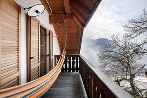 A wooden balcony with a hammock, wooden shutters, and a view of mountains. - Holiday Apartment Ebnicher's Paradise – Retreat with Shared Terrace, Garden and Wi-Fi (Soprabolzano/Renon)