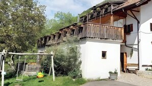 A traditional building with a balcony, a staircase, and a door. - Holiday Apartment Ebnicher's Paradise – Retreat with Shared Terrace, Garden and Wi-Fi (Soprabolzano/Renon)