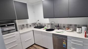 Een microgolfoven, een oven, een kookplaat, een vaatwasser