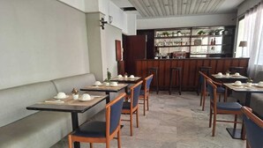 A restaurant with booths and tables, a bar area, and a tiled floor. - hotel BARAKA (Dakar)
