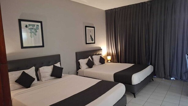 A hotel room with two beds, each with black and white bedding, a headboard, and a framed picture on the wall. - hotel BARAKA (Dakar)
