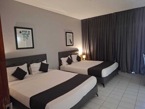 A hotel room with two beds, each with black and white bedding, a headboard, and a framed picture on the wall. - hotel BARAKA (Dakar)