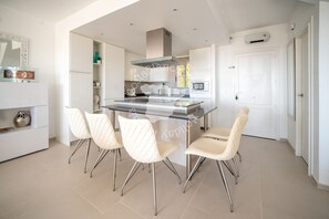 A modern kitchen with a central island, white cabinetry, and four white chairs. - CostaBlancaDreams - Didi in Altea (Altea)