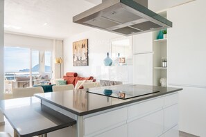 A modern kitchen with a central island, white cabinetry, and a large window offering a view of the outdoors. - CostaBlancaDreams - Didi in Altea (Altea)