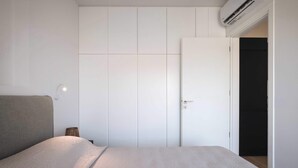 Una camera da letto con un letto, un armadio e un condizionatore d'aria.