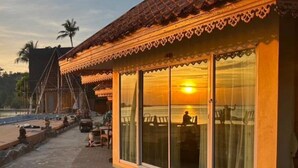 A building with large windows and a tiled roof, overlooking a body of water. - beachfront villa (Ko Chang)