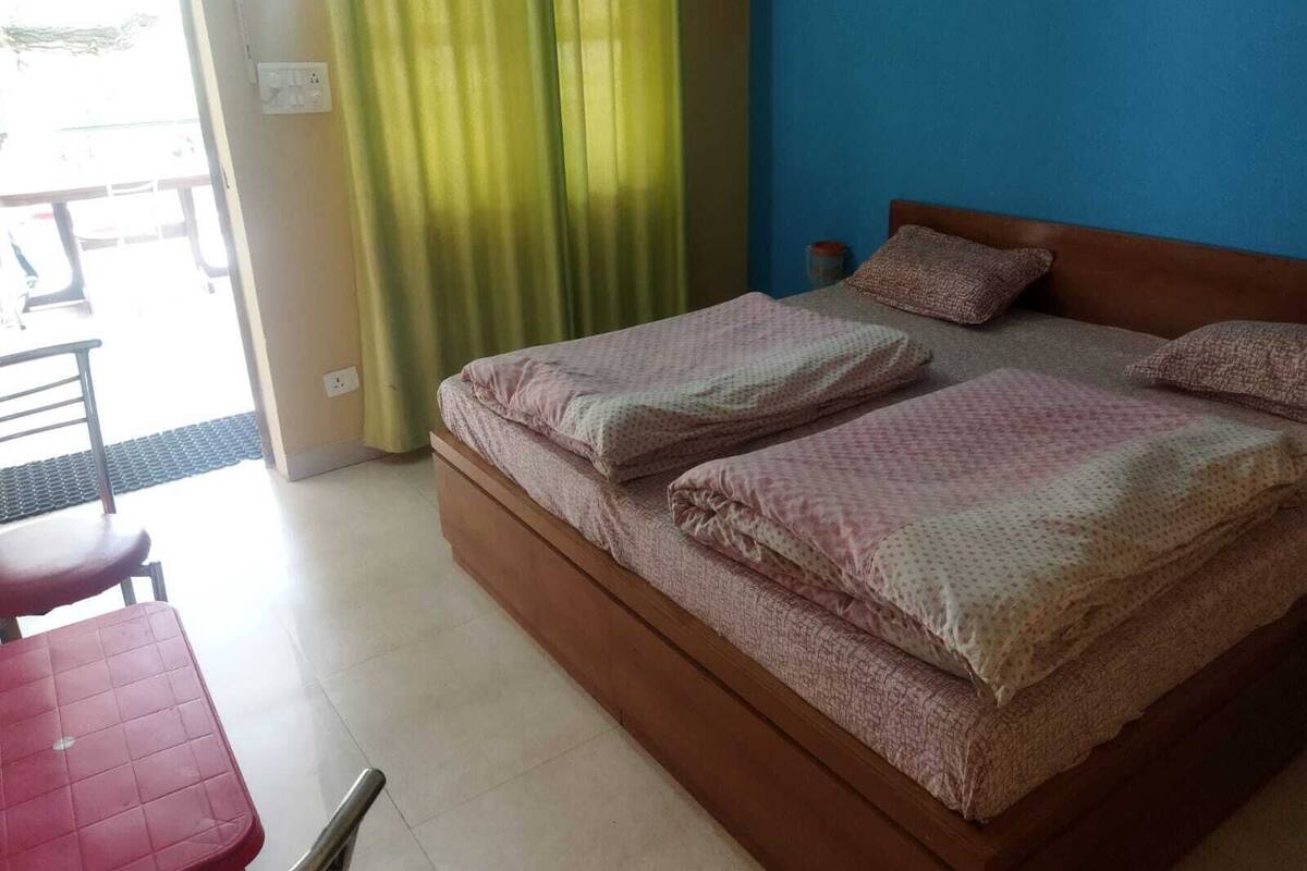 A bedroom with a bed, a chair, and a table.