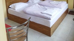 Una cama individual con cabecera de madera en una habitación con paredes amarillas.