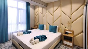 A hotel room with a large bed, two bedside tables, a nightstand, and a window with curtains. - BlueShore International hotel (Tashkent)