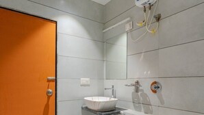 Une salle de bain moderne avec des toilettes blanches, un lavabo blanc et une douche.