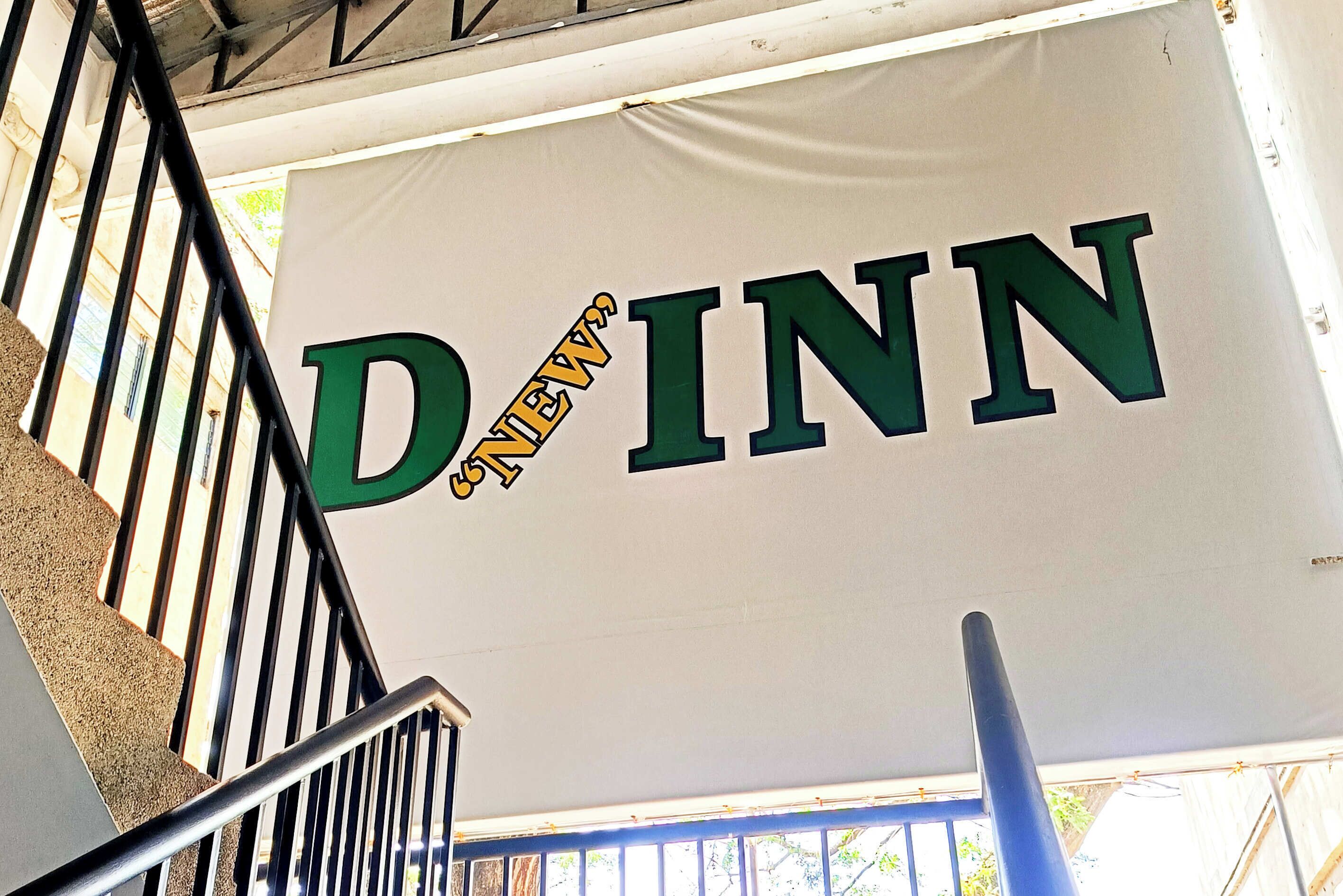 A staircase with a banner hanging that reads "D'Inn".