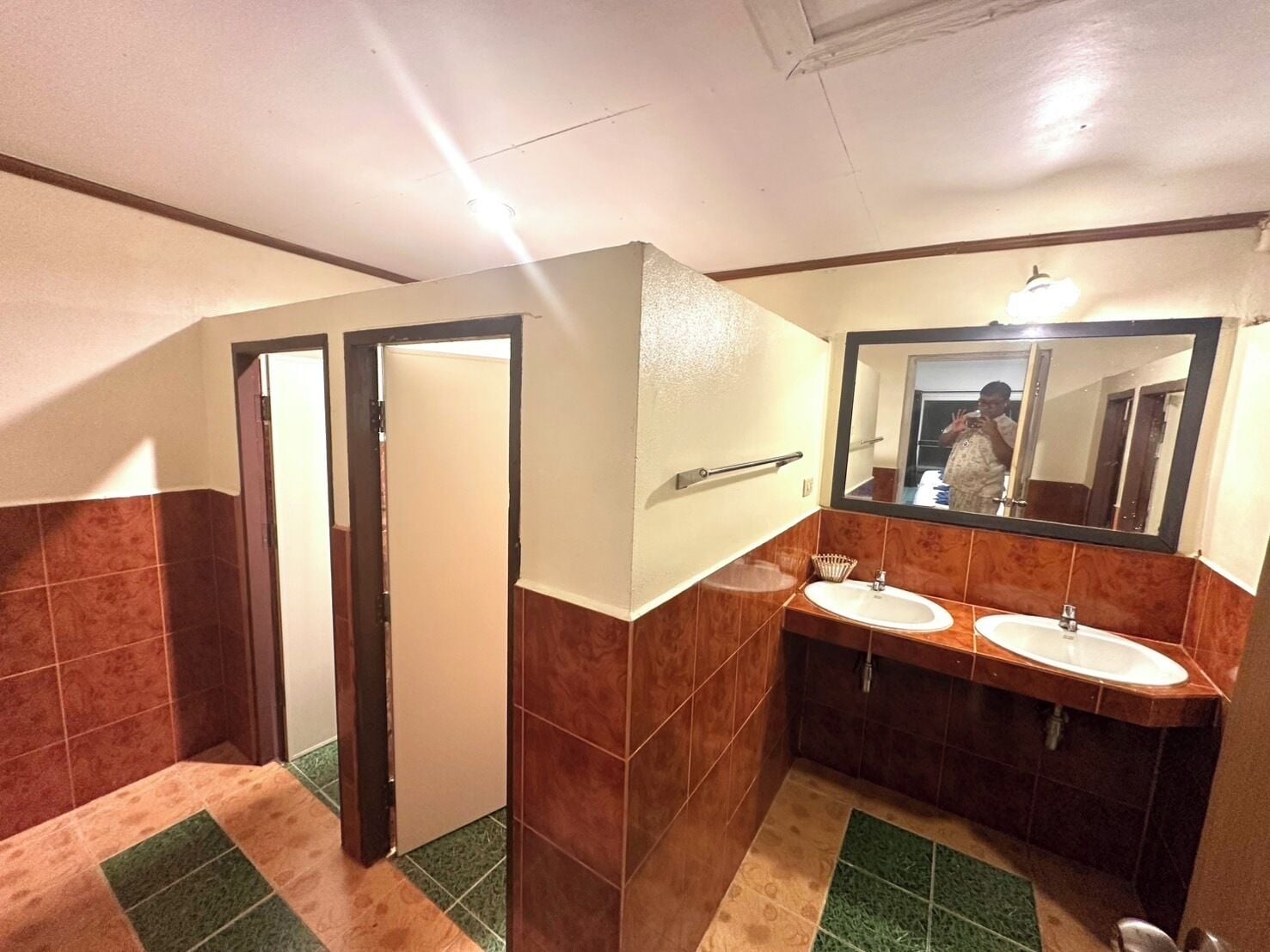 A bathroom with two sinks, a mirror, and a door leading to another room.