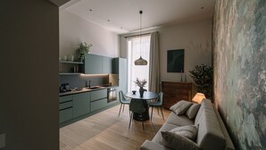 Eine moderne Küche mit Essbereich, einer Couch und einem großen Fenster mit Vorhängen.