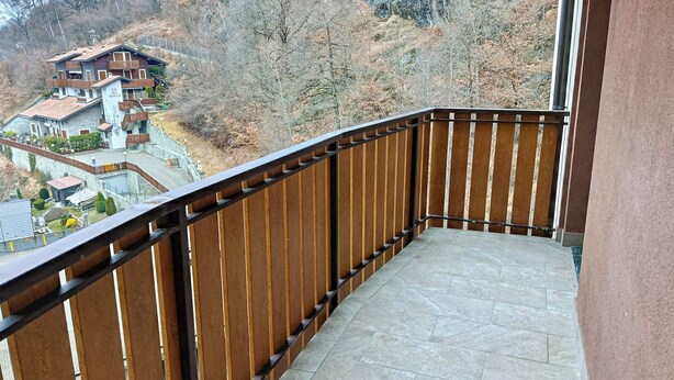 A balcony with a stone floor and a wooden railing. - Gran Paradis Aprica - Casa Giulia (Corteno Golgi)