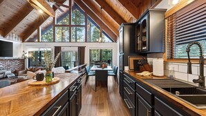 A spacious kitchen with a wooden ceiling, large windows, and a central island. - Modern Cabin • Spa • Firepit & Deck • Near Palisades | Tahoe A-Frame Retreat (Carnelian Bay)