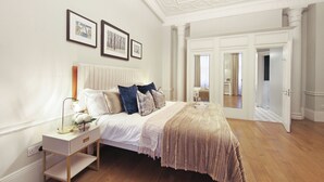 Ein Schlafzimmer mit einem Bett, einem Nachttisch und einer Tür zu einem anderen Raum.
