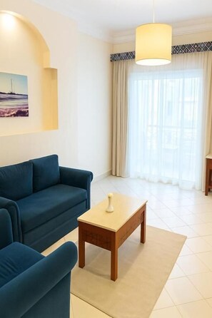 Suite júnior, balcó, vistes al mar | Sala d'estar | Televisor intel·ligent de 34 polzades amb canals per cable 