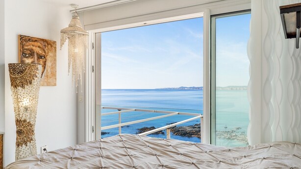 A bedroom with a bed, a large window with a view of the sea, and a chandelier. - Duplex 'Paradise Over the Sea' with Sea Views, Wi-Fi and Air Conditioning (Benalmádena)