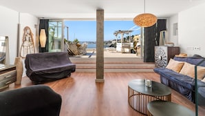 A modern living room with a view of the sea, a sofa, a coffee table, and a dining area with outdoor seating. - Duplex 'Paradise Over the Sea' with Sea Views, Wi-Fi and Air Conditioning (Benalmádena)
