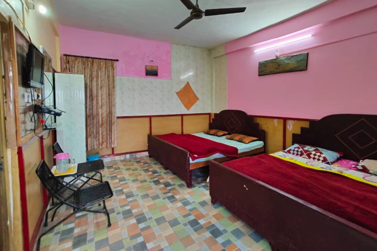 A bedroom with a bed, a desk, a chair, and a ceiling fan.