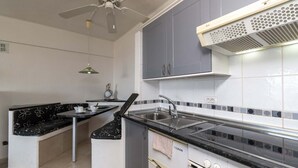 Una cucina compatta con una panca integrata, un fornello e un lavandino.