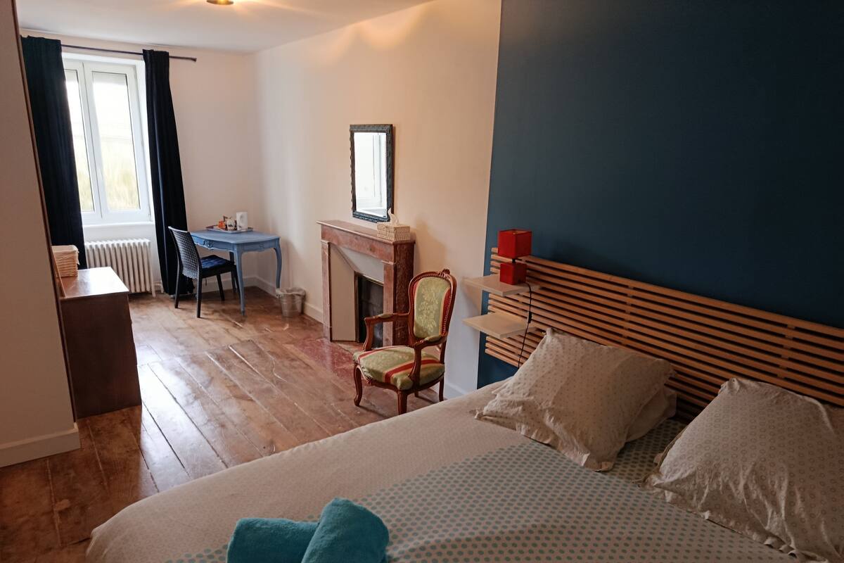 A bedroom with a bed, a desk, and a chair.