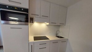 A compact kitchen with a built-in oven, a sink, and a countertop. - CUCOL HUT (Trentino-Alto Adige)