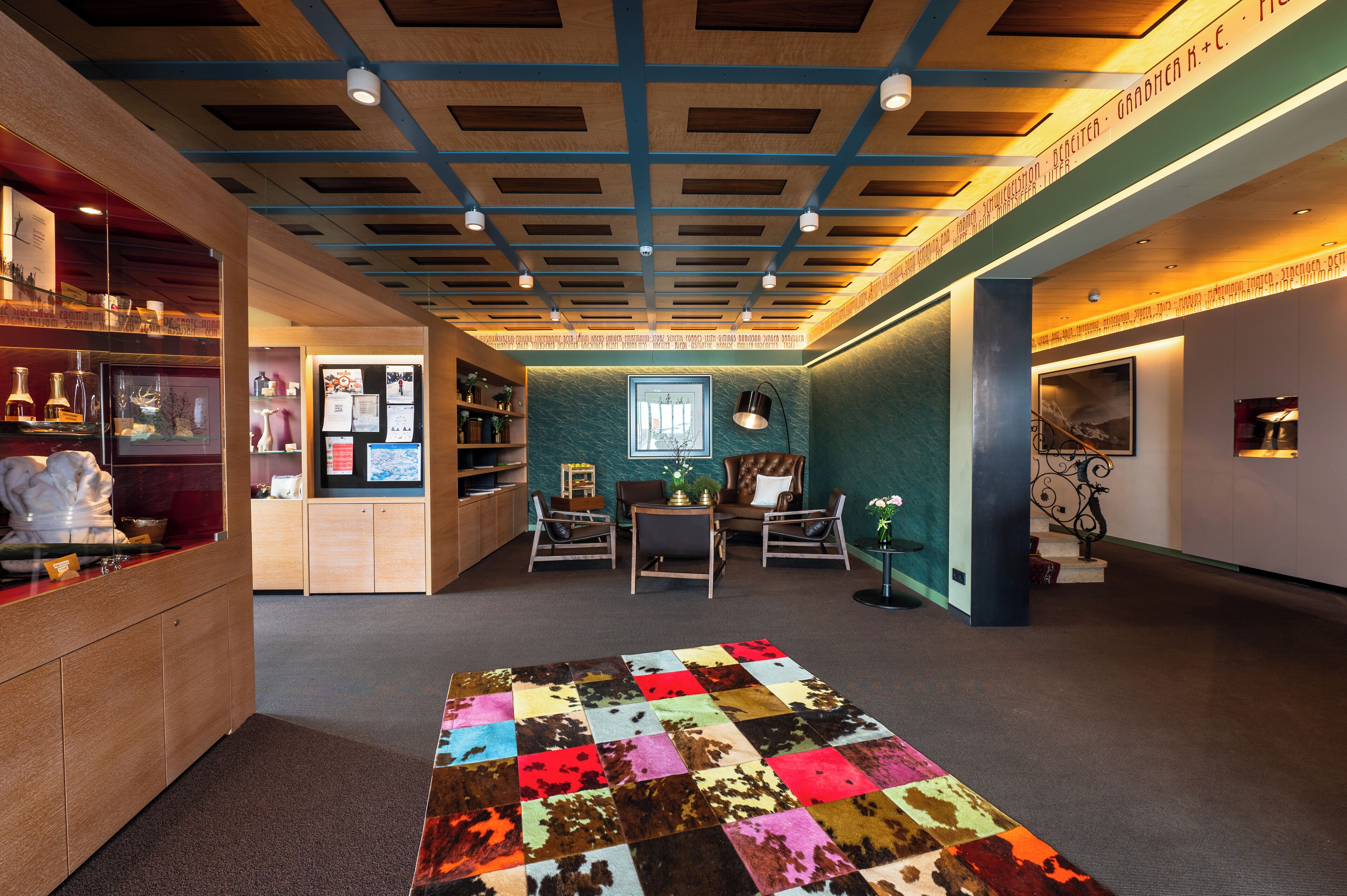 A cozy room with a checkered carpet, wooden furniture, and a ceiling with a grid pattern.