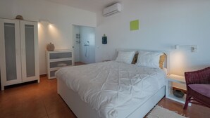 Une chambre à coucher avec un grand lit, une armoire, une étagère et une chaise.