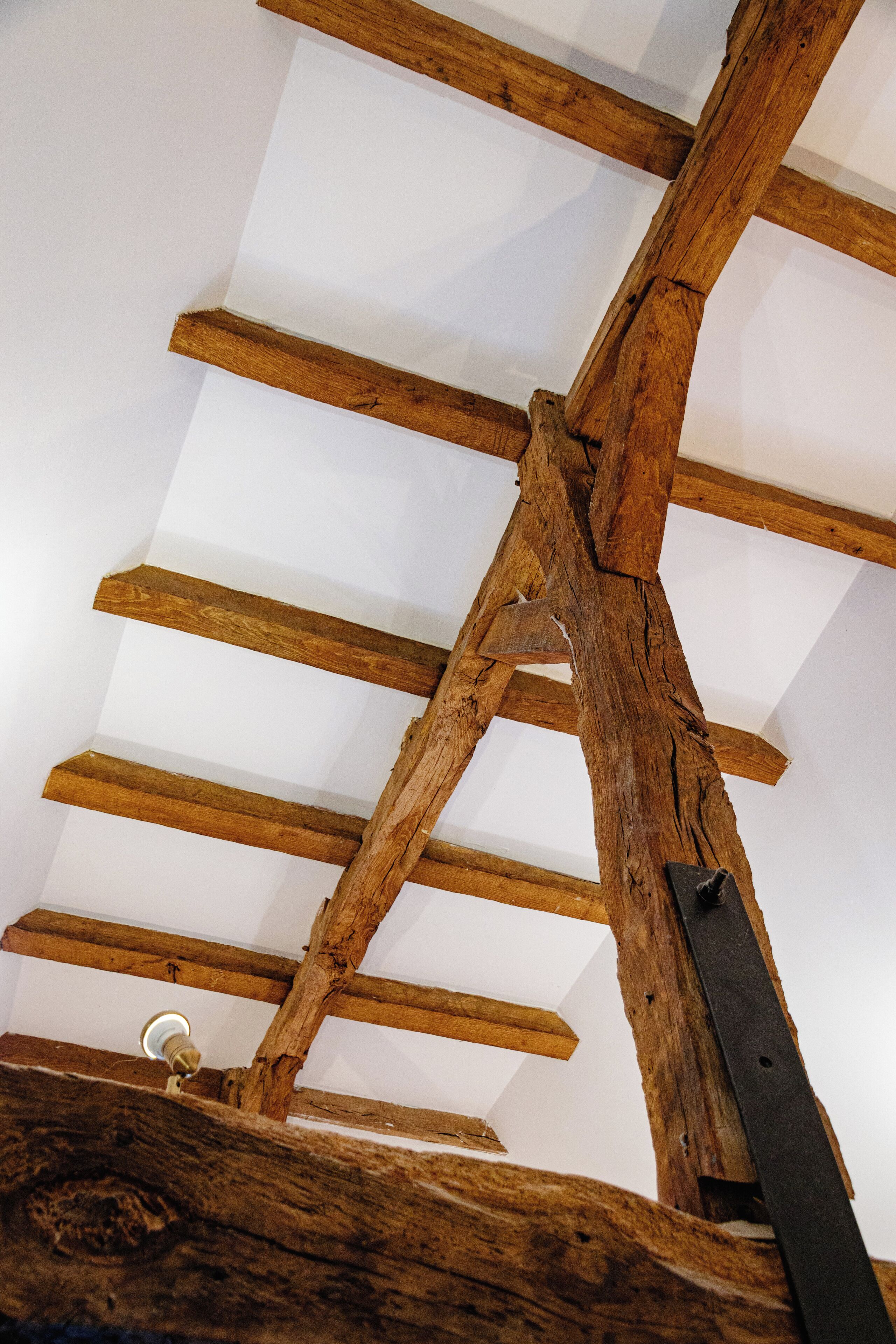 A wooden ceiling structure with exposed beams and a metal bracket.