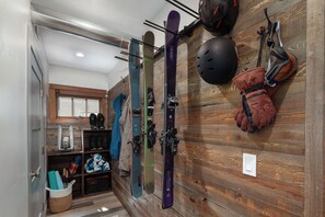 A ski storage area with skis, helmets, and gloves on wooden walls. - Walk downtown/Ski/Play/ Explore Glacier/Hot Tub/Parking (Whitefish)