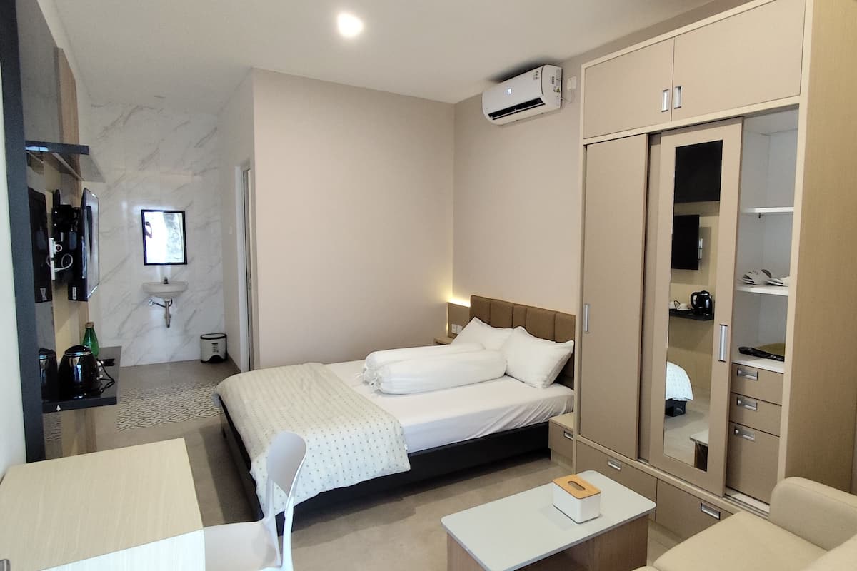 Une chambre d’hôtel avec un lit, une table de chevet et une armoire.