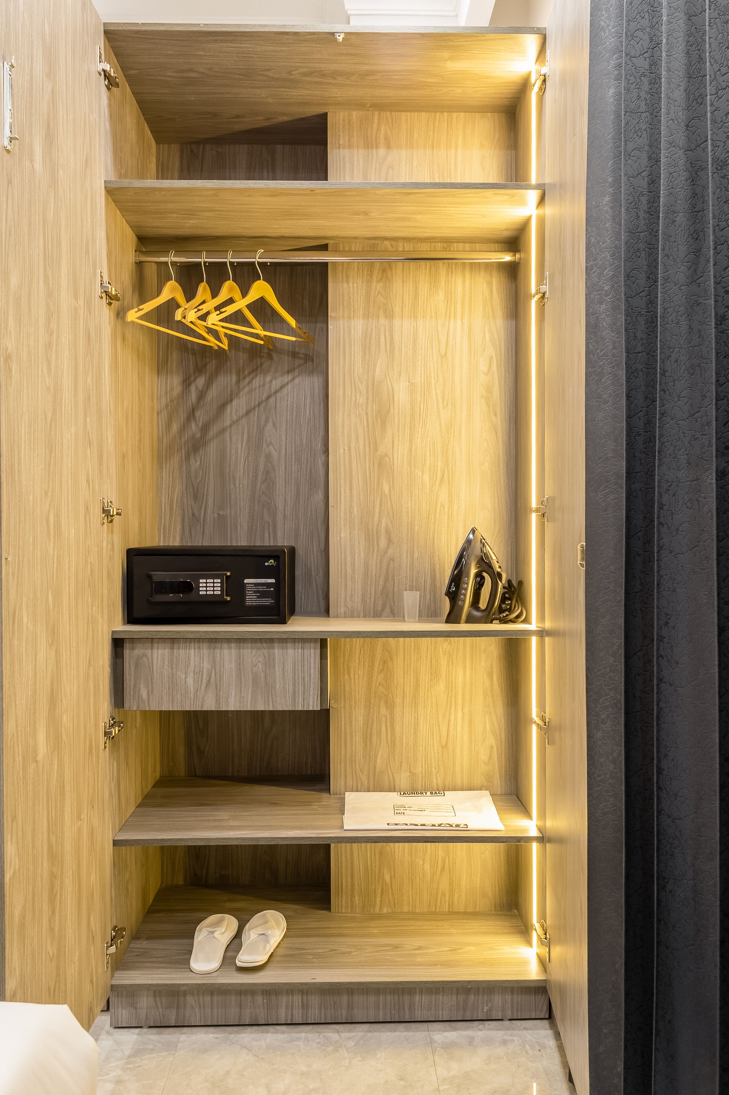 Ein begehbarer Kleiderschrank mit mehreren Regalen, einer Kleiderstange und einem eingebauten Bügelbrett.